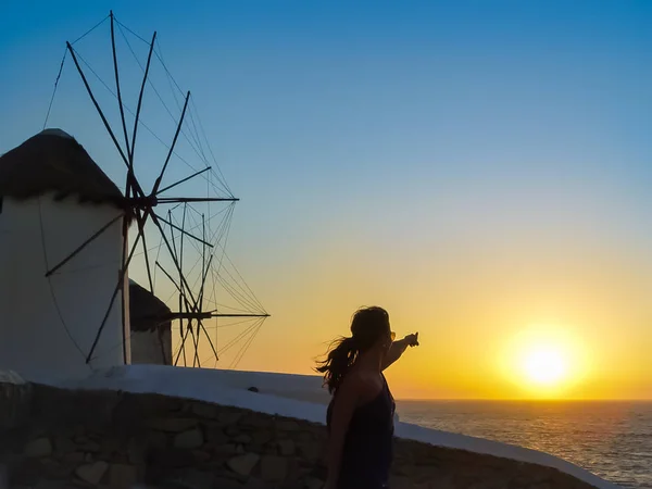 Turista disfrutando de la puesta de sol en los molinos de viento en Mykonos — Foto de Stock