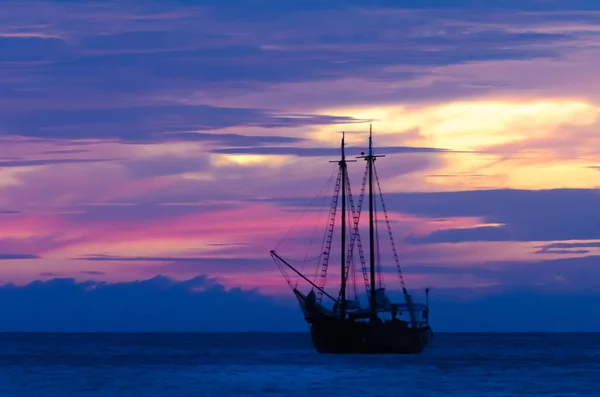 Barca a vela pirata in mare che naviga verso il tramonto — Foto Stock
