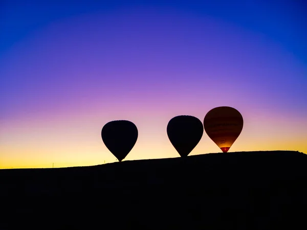 Silhouette von Heißluftballons, die über das Tal von Kappadokien fliegen — Stockfoto