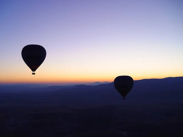 Silhouette von Heißluftballons, die über das Tal von Kappadokien fliegen — Stockfoto