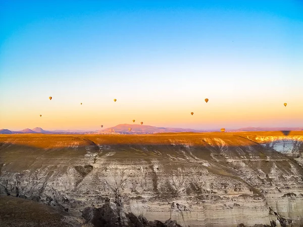 Színes léggömbök repül át a völgy: Cappadocia — Stock Fotó