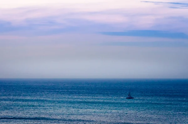 Crepúsculo no mar com silhueta de barco de transporte — Fotografia de Stock