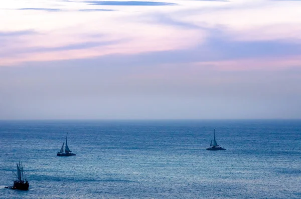 Crepúsculo no mar com silhueta de barco de transporte — Fotografia de Stock