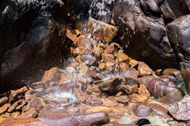 Kayalar ve taşlar yosun arasında küçük şelale