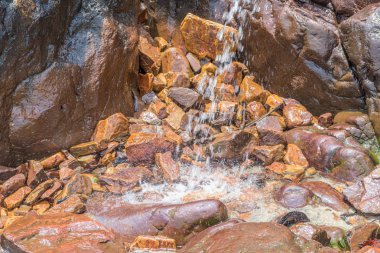 Kayalar ve taşlar yosun arasında küçük şelale