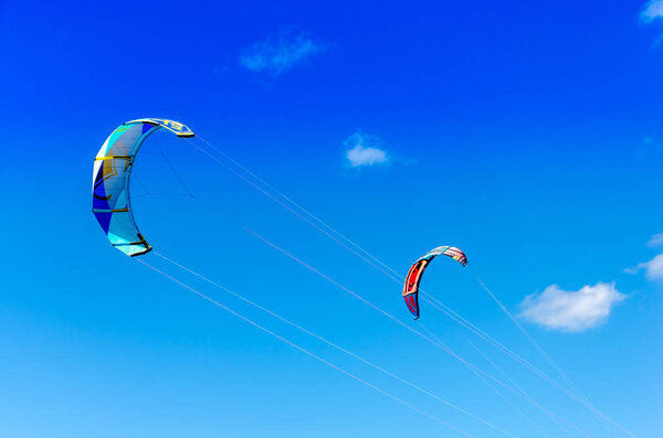 Cumbuco, Brazil, jul 9, 2017: Couple of kitesurfing  close up high by the bright blue sky background