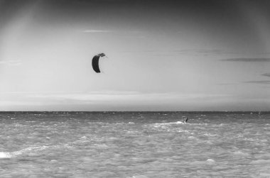 Siyah ve beyaz Günbatımı ile akşam saatlerinde denizin tadını uçurtma sörfçü