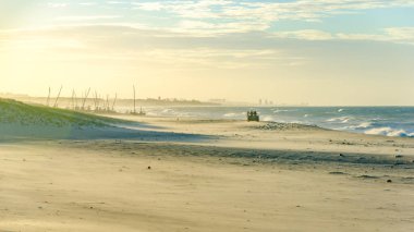 Adamcağız dört bir yanındaki insanlarla batımında sahilde
