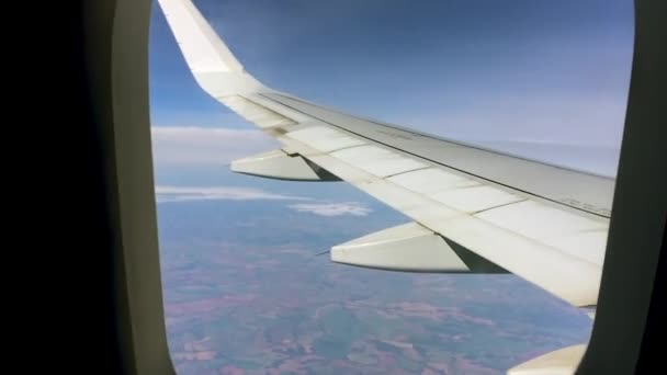 Vidéo d'un avion volant haut dans le ciel bleu. L'aile tremble dans certaines parties en raison de turbulences .