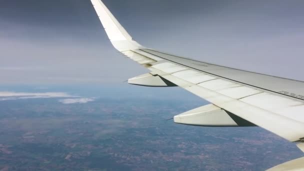 Vidéo d'un avion volant haut dans le ciel bleu. L'aile tremble dans certaines parties en raison de turbulences .