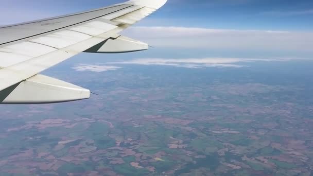 青い空を飛んでいる飛行機のビデオ 乱流の影響で翼がゆらゆらと揺れ — ストック動画