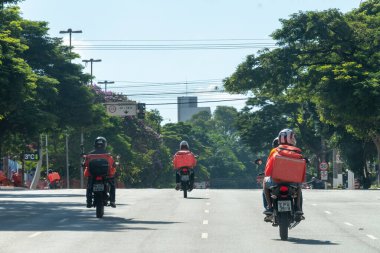 Sao Paulo, Brezilya - 5 Nisan 2020: bir salgın hastalık. Sokakta hiç araba yok, sadece yiyecek ve paket getiren motorcular var..