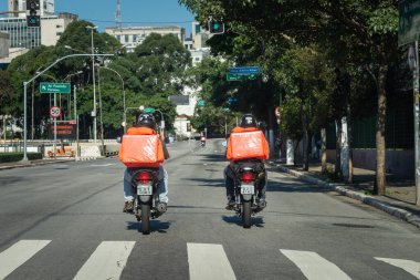 Sao Paulo, Brezilya - 5 Nisan 2020: bir salgın hastalık. Sokakta hiç araba yok, sadece yiyecek ve paket getiren motorcular var..