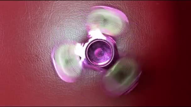 Tournage d'un jouet spinner à grande vitesse sur fond rouge 