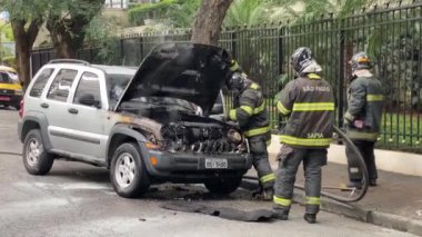 Sao Paulo, Brezilya - 14 Nisan 2020: Alev almış bir araba motorundaki yangını önlemek için itfaiyeci harekete geçti.