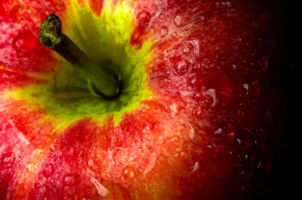Gotas de água na superfície brilhante da maçã vermelha no fundo preto — Fotografia de Stock