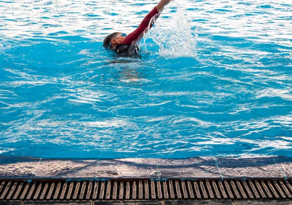Nadador e ondulação na superfície da água na piscina — Fotografia de Stock