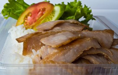 Plastik bir kutuda kızarmış domuz ve pirinç.