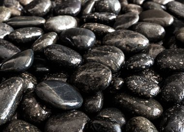 Yuvarlak kara taş şelale yanında zemin üzerine