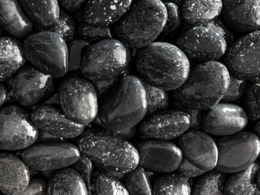 Yuvarlak kara taş şelale yanında zemin üzerine