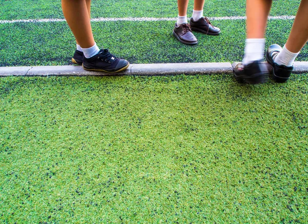 Children in the artificial turf of the school — Stock Photo, Image