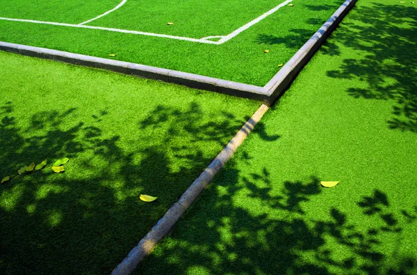 Sombra de árbol y hoja de otoño en la fi de fútbol césped artificial —  Fotos de Stock