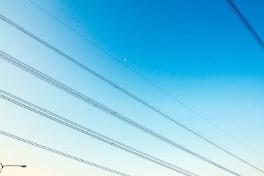 Elektrik kablolarının mavi gökyüzü çapraz