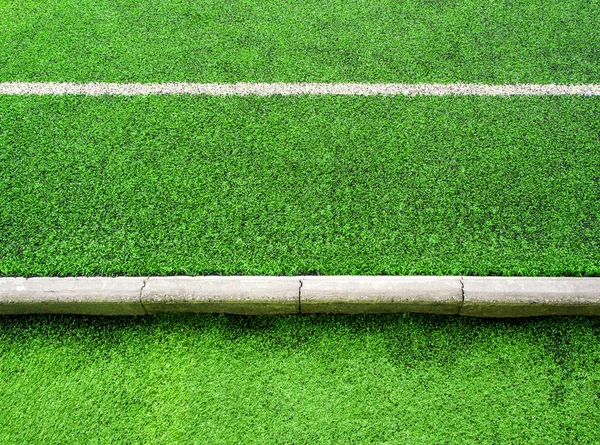 Текстура пластичної штучної трави та бетонної межі школи — стокове фото