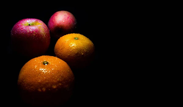 Gouttelettes d'eau sur une surface brillante de fraîcheur orange et rouge pomme — Photo