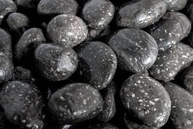 Yuvarlak kara taş şelale yanında zemin üzerine