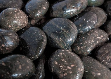 Islak zeminde siyah dere taşı yüzey şelale yanında