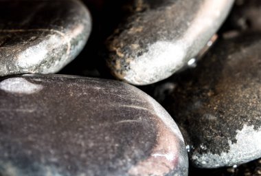 Yuvarlak kara taş şelale yanında zemin üzerine