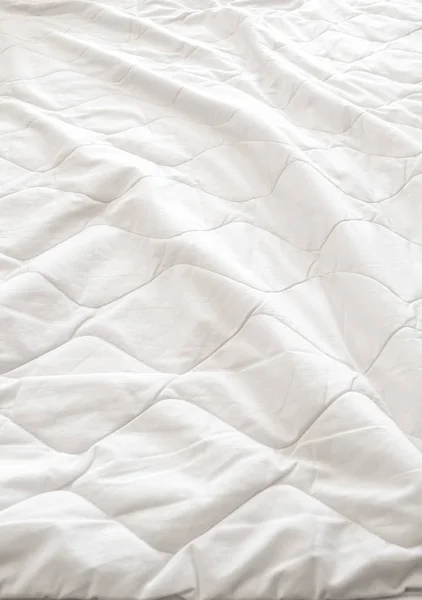Bílá přikrývka se zhroutila na posteli — Stock fotografie