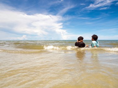Sahildeki çocuklar ve geniş deniz manzarası.