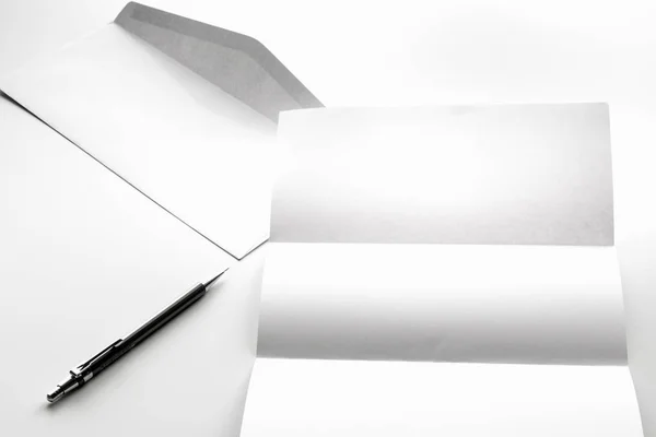 Κενό γράμμα χαρτιού και λευκό φάκελο με στυλό — Φωτογραφία Αρχείου