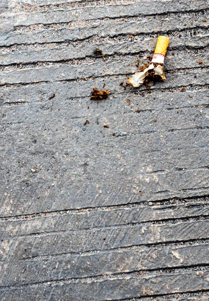 Le mégot de cigarette laissé tomber sur le sol en béton — Photo