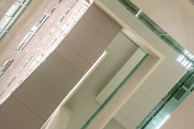 Koridordaki yüksek binadaki alçak görüş açısı binanın tepesindeki rahipten gelen gün ışığına bakıyor.