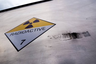 Tehlikeli madde taşıma etiketinde radyasyon uyarısı işareti var. Sınıf 7, nakliye kamyonunun alüminyum konteynerinde.