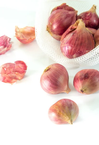 Cipolle Rosse Sacchetto Maglia Alcune Sul Pavimento Isolato Sfondo Bianco — Foto Stock