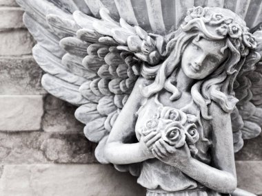 Taş doku duvarına süslü peri heykeli.