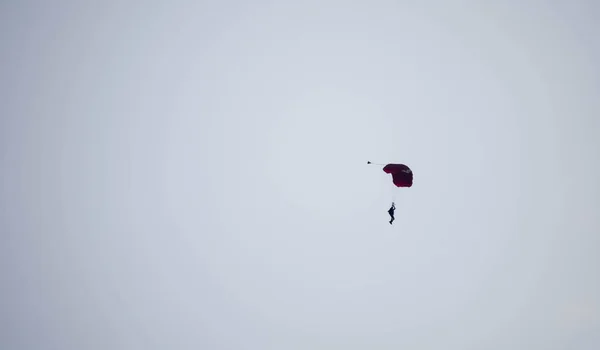 Sylwetka spadochron wyczyn nieostry i nieostry podczas szybowania w — Zdjęcie stockowe