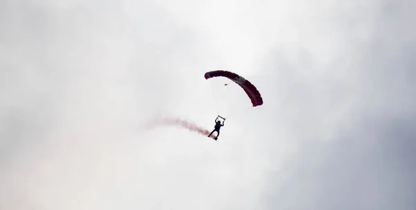 Silhouette paracadute acrobazia sfocata e sfocata mentre scivola in — Foto Stock