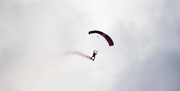 Silhueta paraquedas acrobacia desfocado e embaçado enquanto deslizando em — Fotografia de Stock