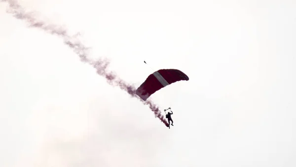 Silhouet parachute stunt ongericht en wazig tijdens het glijden in — Stockfoto