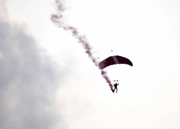 Silhueta paraquedas acrobacia desfocado e embaçado enquanto deslizando em — Fotografia de Stock