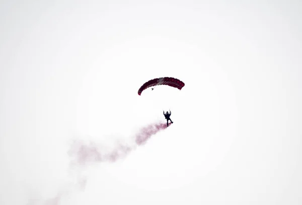 Silhueta paraquedas acrobacia desfocado e embaçado enquanto deslizando em — Fotografia de Stock