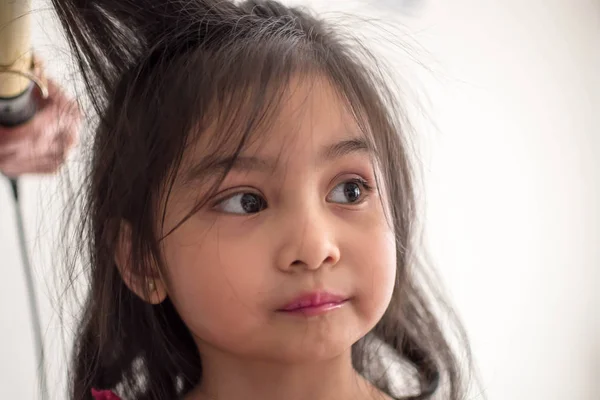 Стилист кёрлинг волос для маленькой девочки в гостиной — стоковое фото
