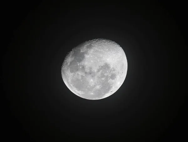 Moon through telescope with visible craters and the sea of tranq