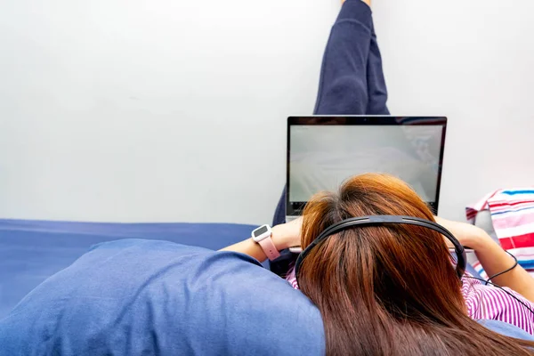 Uma Garota Trabalhando Casa Sua Cama Com Laptop Fone Ouvido — Fotografia de Stock