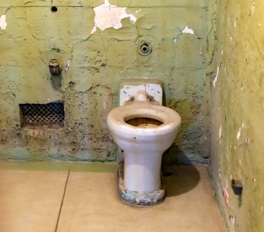 Broken rusty and dirty sink and toilet bowl from a cell at Alcatraz Prison San Francisco California USA clipart